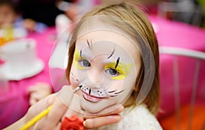 Face painting for cute little girl during kids birthday party