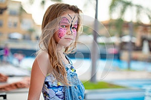 Face painting pink butterfly on little girl