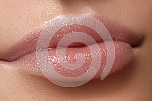 Face part. Beautiful female lips with natural makeup, clean skin. Macro shot of female lip, clean skin. Fresh kiss.