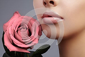 Face part. Beautiful female lips with natural makeup, clean skin. Macro shot of female lip, clean skin. Fresh kiss. photo