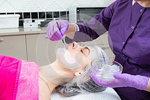 Face peeling mask, spa beauty treatment, skincare. Woman getting facial care by beautician at spa salon