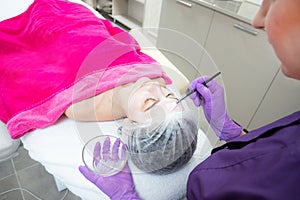 Face peeling mask, spa beauty treatment, skincare. Woman getting facial care by beautician at spa salon