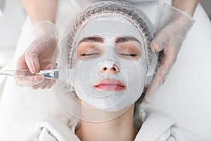 Face peeling mask, spa beauty treatment, skincare. Woman getting facial care by beautician at spa salon.