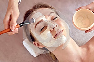 Face peeling mask, spa beauty treatment, skincare. Woman getting facial care by beautician at spa salon, close-up