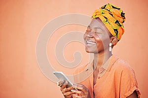 Face, phone and black woman on social media in studio, texting or internet browsing on an orange mockup background