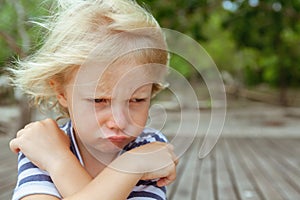 Face portrait of annoyed, unhappy caucasian kid with crossed arms