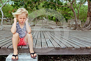 Face portrait of annoyed, unhappy caucasian kid with crossed arms photo