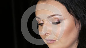 Face portrait of a beautiful luxurious young woman model with evening make-up smoky eyes posing in front of the camera