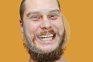 Face portrait of laughing happy bearded unshaven guy on isolated background