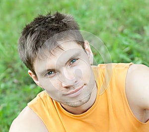 Face portrait of man sitting on a grass