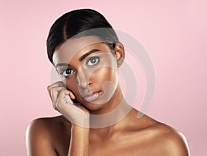 Face portrait, skincare and serious woman in studio isolated on a pink background. Natural beauty, aesthetic and Indian