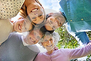 Face portrait, smile and circle of happy family hug, grandparents and parents bond with kid in nature park. Solidarity