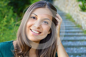 Face portrait of smiling woman with hand between hair. Teeth smiling girl. One model portrait.