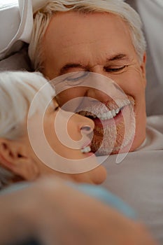 Face-portrait of white-haired vigorous man looking at silver-haired beautiful wife
