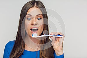 Face portrait of woman smiling with teeth holding toothy brush.