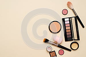 Face powder, brush and various cosmetic decorative makeup products on a color background. Close up. Makeup brush and