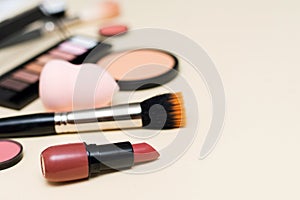 Face powder, brush and various cosmetic decorative makeup products on a color background. Close up. Makeup brush and