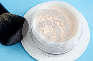 Face powder in the white jar close up and make-up brush