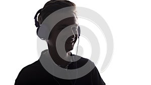 Face profile silhouette of music lover teenager listening to favorite song in headphones , handsome young man on white 