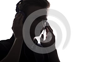 Face profile silhouette of music lover teenager listening to favorite song in headphones , handsome young man on white 
