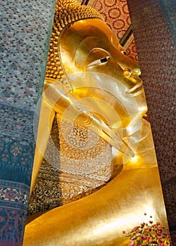Face of Reclining Buddha gold statue in Bangkok, Thailand