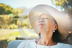 Face, relax and a senior woman in the garden of her home during summer to enjoy retirement. Nature, peace and quiet with