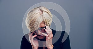 Face, sad and crying with a mature woman in studio on a gray background for the expression of emotion. Depression