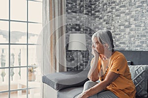 Face of senior caucasian hoary woman looking away deep in sad thoughts feels lonely close up portrait, recollect memories and life photo