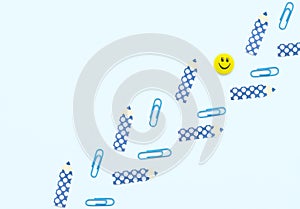 Face shaped yellow magnet, blue clips, pencil shaped paper stickers on white background. School and office supplies, stationary.