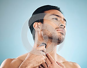 Face, shaving and electric razor with a man in studio on a blue background for personal hygiene, skincare or grooming