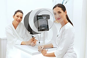 Face Skin Analyze. Cosmetologist Analyzing Woman Facial Skin