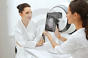 Face Skin Analyze. Cosmetologist Analyzing Woman Facial Skin