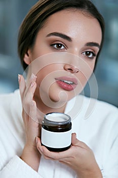 Face Skin Care. Beautiful Woman Applying Cream On Facial Skin