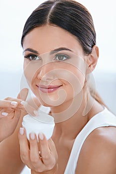 Face Skin Care. Beautiful Woman With Facial Cream. Cosmetics