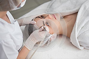 Face Skin Care. Close-up Of Woman Getting Facial Hydro Microdermabrasion Peeling Treatment At Cosmetic Beauty Spa Clinic photo