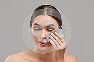 Face skin care. Smiling woman using facial oil blotting paper portrait.