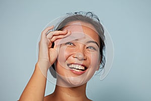 Face skin care. Smiling woman using oil blotting paper portrait