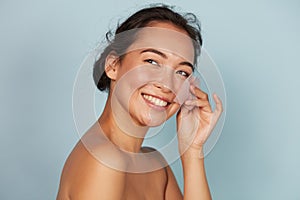 Face skin care. Smiling woman using oil blotting paper portrait