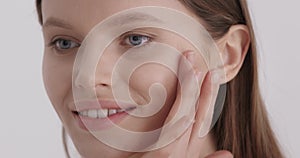 Face skin care. Woman applying cosmetic serum on face skin