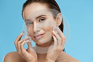 Face Skin Care. Woman Applying Ice Cubes