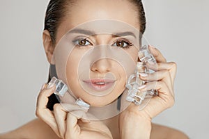 Face Skin Care. Woman Applying Ice Cubes