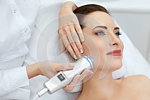 Face Skin Care. Woman Doing Blue Light Therapy At Beauty Clinic