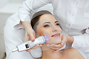 Face Skin Care. Woman Doing Blue Light Therapy At Beauty Clinic