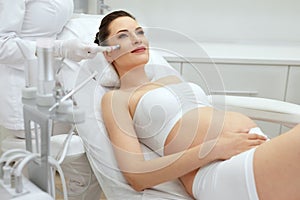 Face Skin Cryo Therapy. Pregnant Woman At Cosmetology Treatment photo