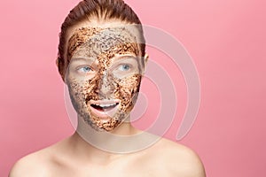 Face Skin Scrub. Portrait Of Smiling Female Model Applying Natural Coffee Mask, Face Scrub On Facial Skin. Closeup