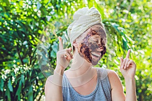 Face Skin Scrub. Portrait Of Smiling Female Model Applying Natural Coffee Mask, Face Scrub On Facial Skin. Closeup Of Beautif