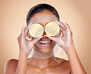 Face, skincare or happy woman with lemon for health, wellness or vitality  on studio background. Girl, smile or