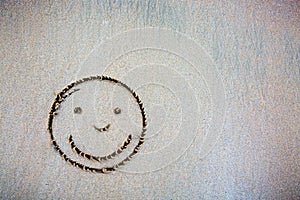 Face smail drawing in the sand .