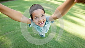 Face, smile and boy spinning in garden with parent for love, fun or bonding together as family. Portrait, energy or