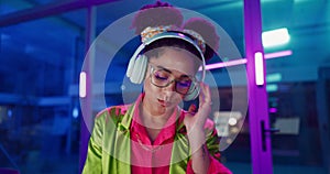 Face, smile and woman in headphones, neon and listening to music on digital interface. Portrait, glasses and person